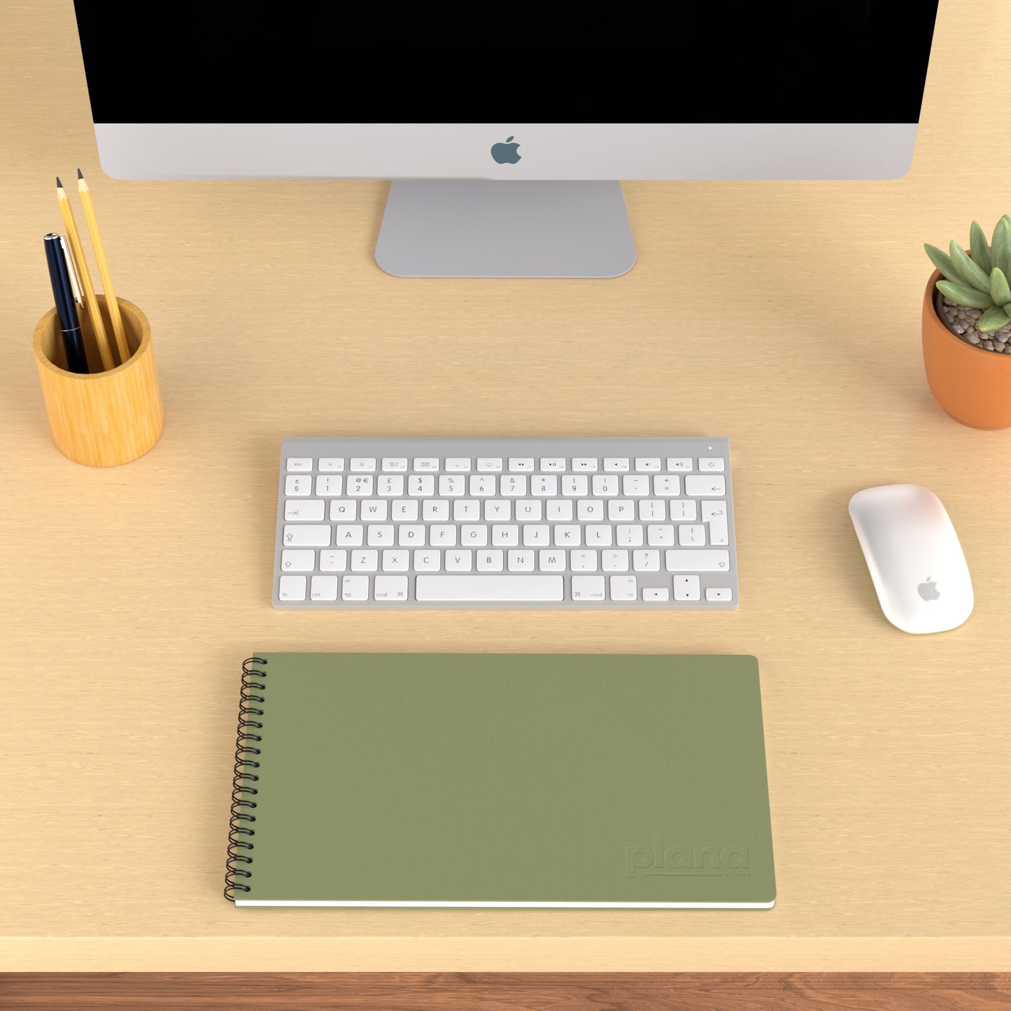 Plana Classic Cedar on a wooden desk with a computer, pen holder, and plant