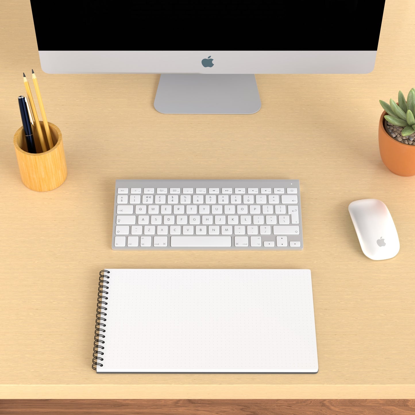 Plana Classic opened on a wooden desk with a computer, pen holder, and plant