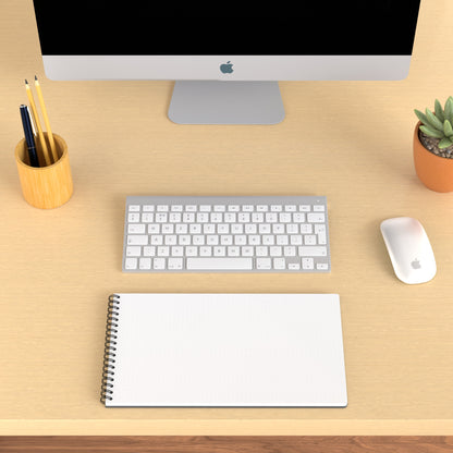 Plana Classic opened on a wooden desk with a computer, pen holder, and plant