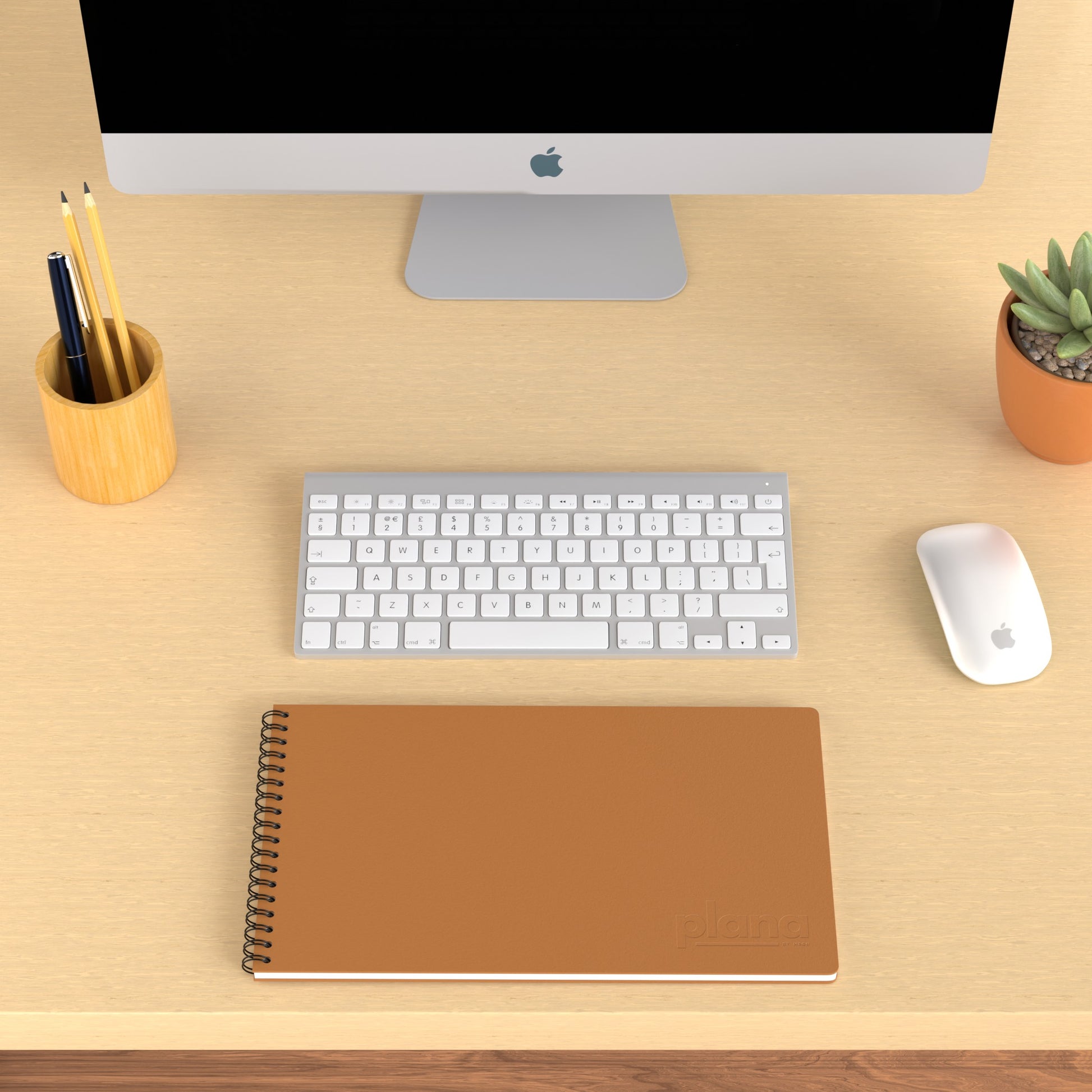 Plana Classic Spritz on a wooden desk with a computer, pen holder, and plant
