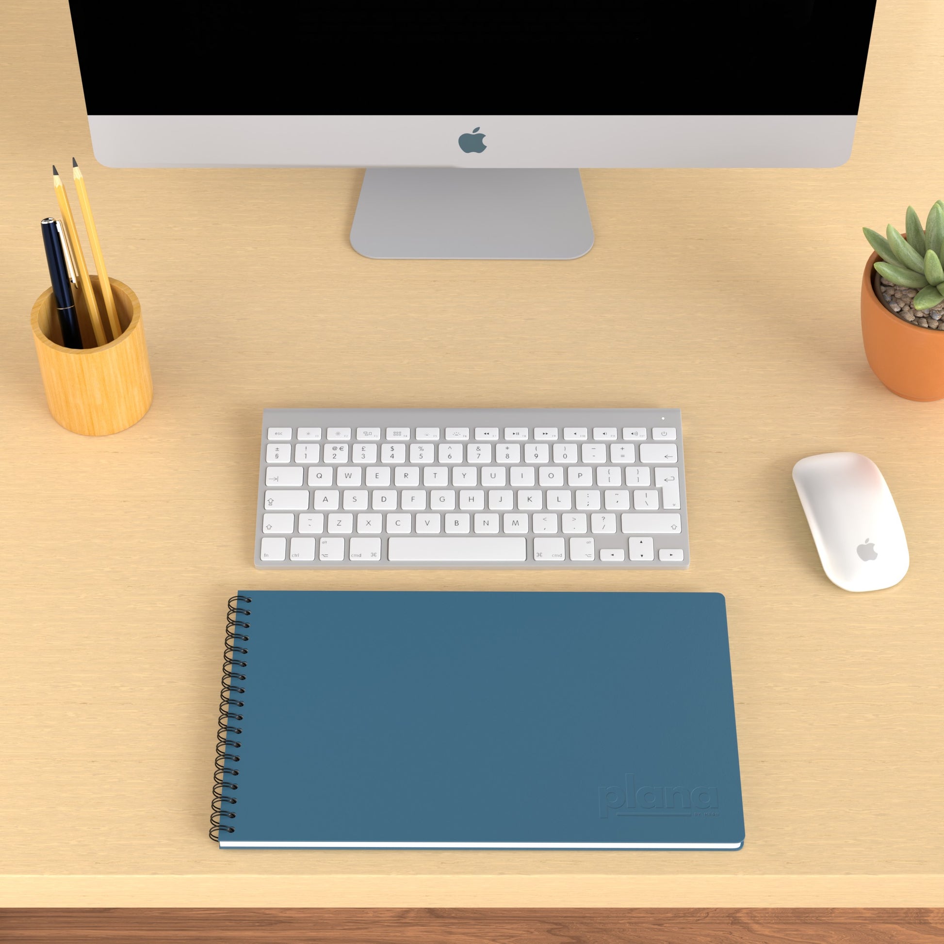 Plana Pro Graphite on a wooden desk with a computer, pen holder, and plant
